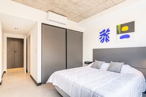 Ein modernes Schlafzimmer mit einem großen Bett, einem Kleiderschrank und Bildern an der Wand.