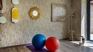 A room with exercise equipment, a yoga mat, and a cat.
