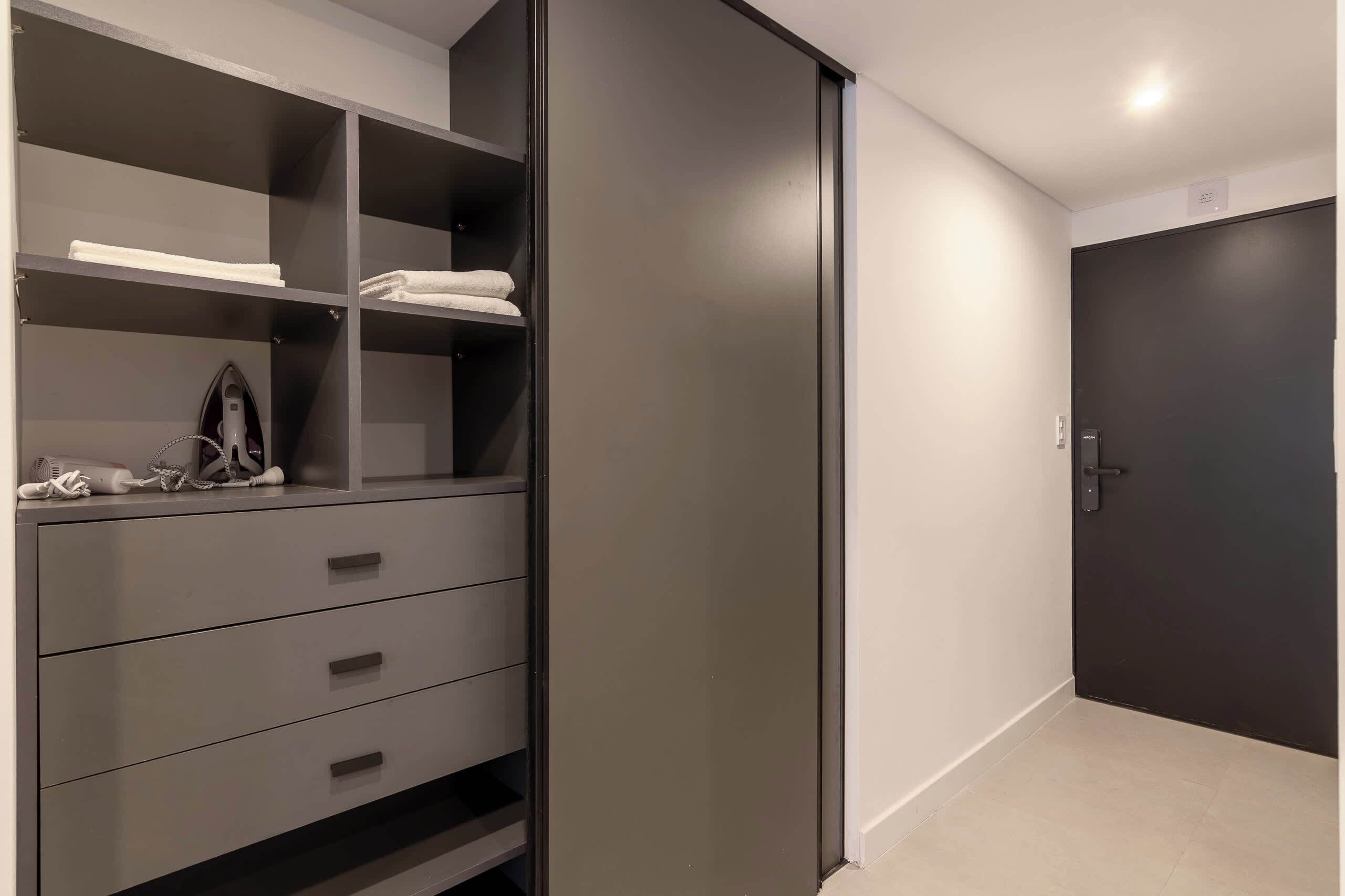 Una habitación con armario, puerta y suelo de baldosas.