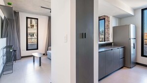 A modern kitchen with a built-in refrigerator, a dining area with a table and chairs, and a large window with a view of the city. - Soho Village en Palermo by Magno | 802 (Buenos Aires)