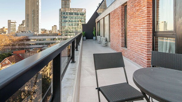 A balcony with a view of a cityscape, featuring modern buildings and a clear sky. - Soho Village en Palermo by Magno | 802 (Buenos Aires)