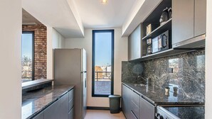 A modern kitchen with a built-in oven, a window, and a view of the outside. - Soho Village en Palermo by Magno | 802 (Buenos Aires)