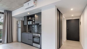 A modern kitchen with a built-in oven, a refrigerator, and a microwave. - Soho Village en Palermo by Magno | 203 (Buenos Aires)