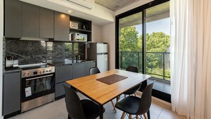 Eine moderne Küche mit großem Fenster, einem Esstisch und integrierten Geräten.