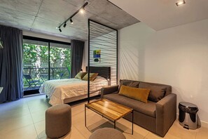 Une chambre à coucher moderne avec un lit, un canapé et une petite table.