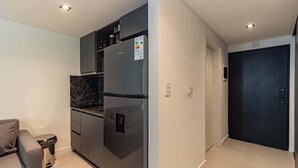 Eine moderne Küche mit integriertem Kühlschrank, einem dunkelbraunen Backofen und einer Marmorarbeitsplatte.