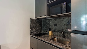 Eine Küche mit einer Granit Arbeitsplatte, Edelstahlgeräten und einem eingebauten Backofen.