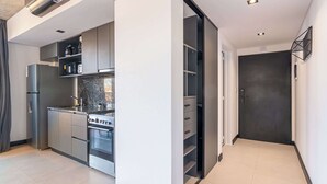 Una cucina moderna con elettrodomestici integrati, una porta scura e un design minimalista.