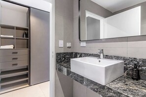 A modern bathroom with a white sink, a large mirror, and a marble countertop. - Soho Village en Palermo by Magno | 304 (Buenos Aires)