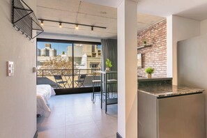 Een modern appartement met balkon, een keuken en uitzicht op gebouwen.