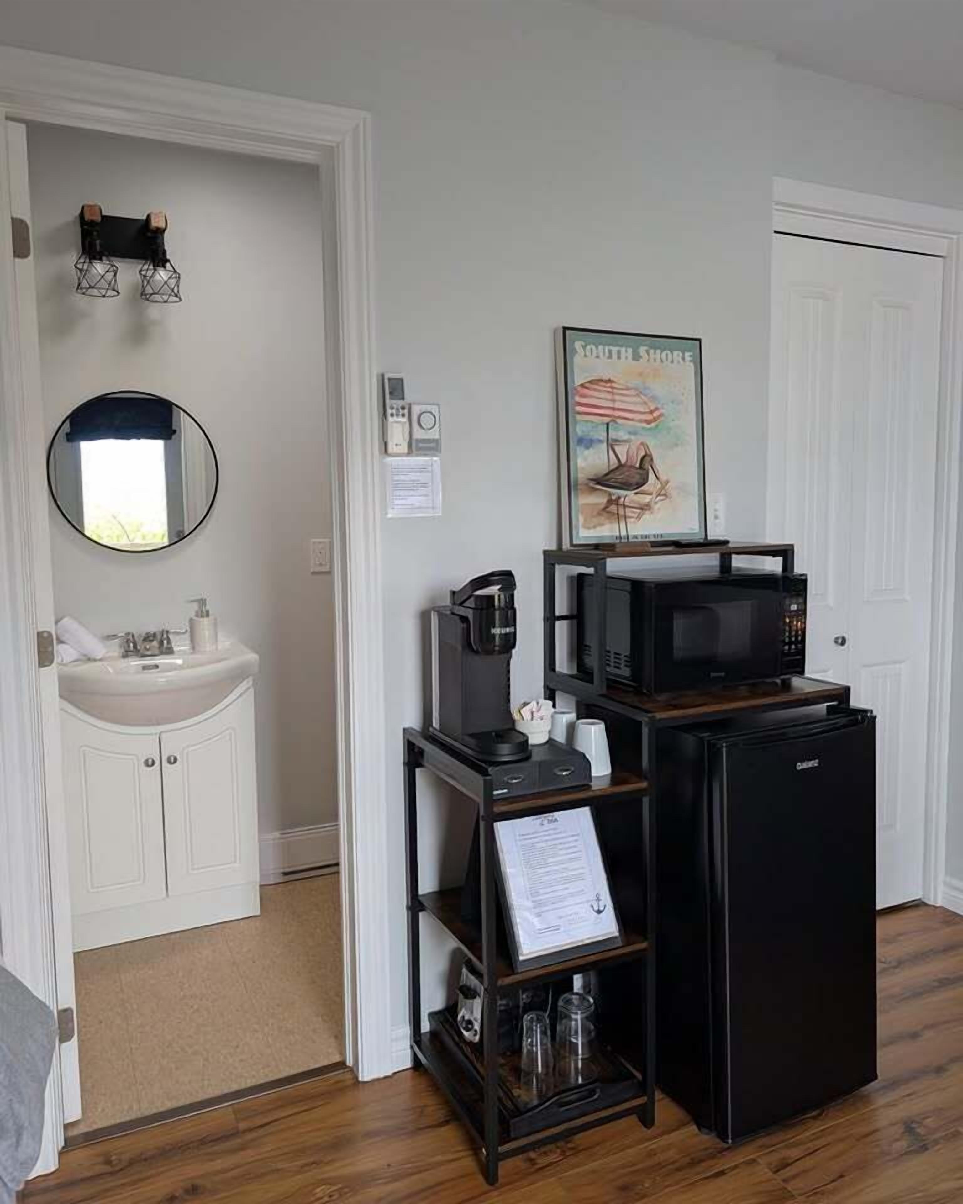 A compact kitchenette with a microwave, coffee maker, and refrigerator.