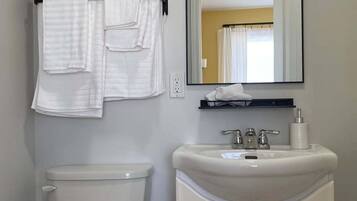 Une salle de bain avec des toilettes, un lavabo et un miroir.