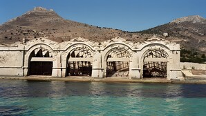 A historical stone structure with arched doorways and a view of a hill with ruins in the background. - Case Vacanza Edera - Orchidea near Trapani Port (Trapani)