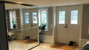 A room with a large mirror, a sliding door, a small window, and a door with a window. - Large farmhouse near lake & forest • Boat included (Svängsta)