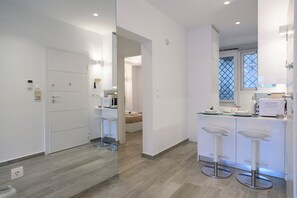 Una cocina moderna con microondas, fregadero y taburetes de bar.