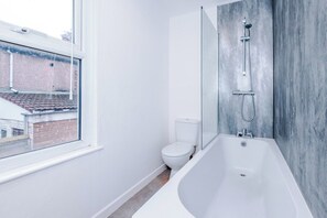 A modern bathroom with a bathtub, toilet, and a glass shower enclosure. - 3BR House | 15 min Walk to Anfield | Free Parking (Liverpool)
