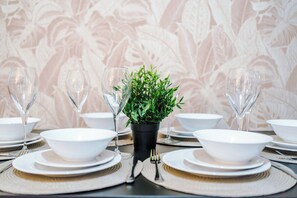 A table set with white plates, bowls, and glasses, with a small potted plant in the center. - 3BR House | 15 min Walk to Anfield | Free Parking (Liverpool)