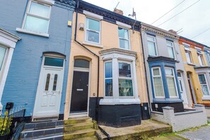 A row of terraced houses with distinct front doors and windows. - 3BR House | 15 min Walk to Anfield | Free Parking (Liverpool)