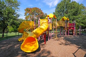 A playground with a yellow slide and climbing structures. - Family Suite King Queen Queen + Queen sofa bed / Free Parking (Arlington)