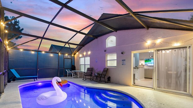 Ein Hallenbad mit einem Schwan-Schwimmpferd, Stühlen und einer überdachten Terrasse.