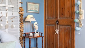 A room with a wooden door, a wall-mounted lamp, and a table with decorative items. - Bed and Breakfast 'Chez Sophie - Chambre Côté Mer' with Mountain View, Wi-Fi and Air Conditioning (Roquebrune-sur-Argens)