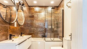 Ein modernes Badezimmer mit Badewanne, Dusche und Toilette.