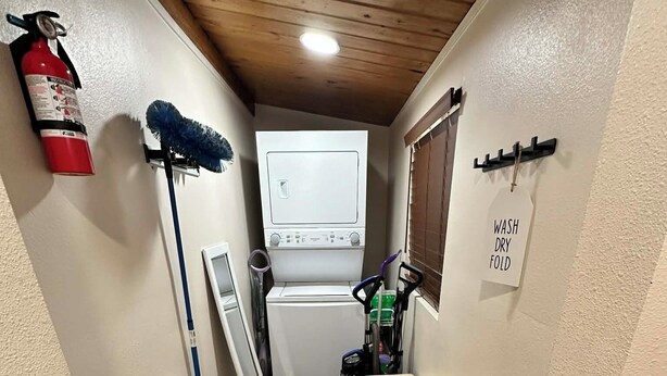 A laundry room with a washing machine, a drying rack, a bench, a fire extinguisher, and a 'WASH DRY FOLD' sign. - 3-bedroom cabin in amazing Running Springs with cozy vibes (Running Springs)