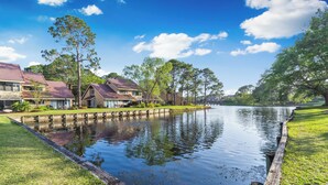 A residential area with houses, a calm water body, and a grassy park area. - 3 Pools - PET FRIENDLY - Gulfside of Sandestin Resort (Miramar Beach)