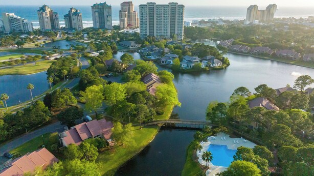 A residential area with a river, houses, and high-rise buildings in the background. - 3 Pools - PET FRIENDLY - Gulfside of Sandestin Resort (Miramar Beach)