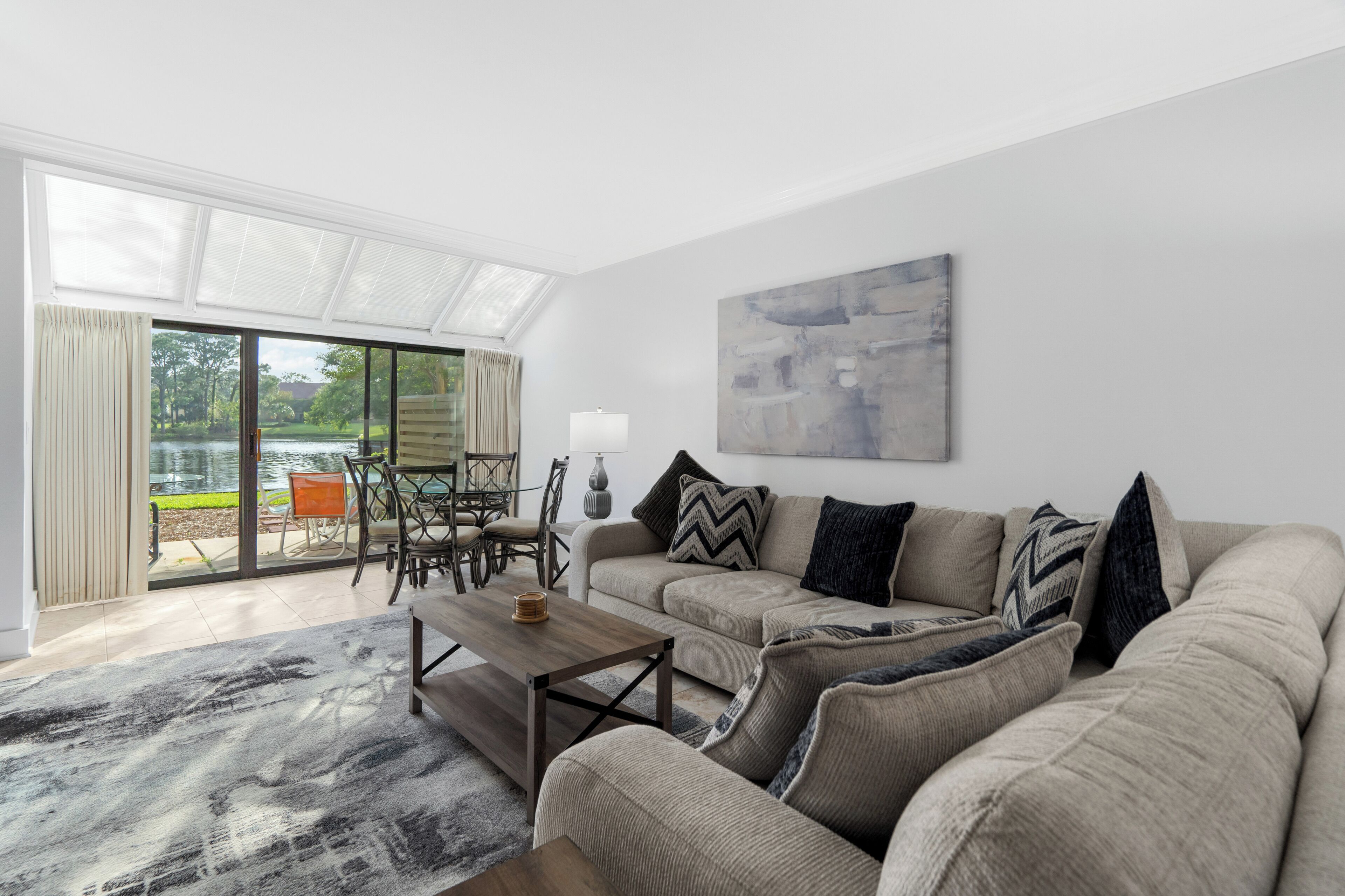 A modern living room with a sofa, coffee table, and a painting on the wall.