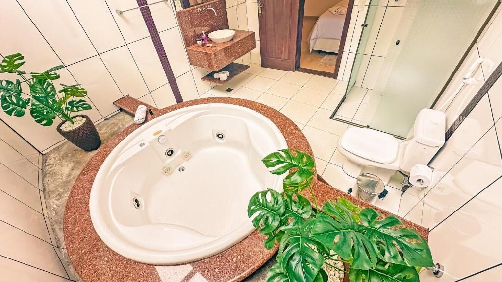 A bathroom with a freestanding bathtub, a sink, a mirror, and a shower area.
