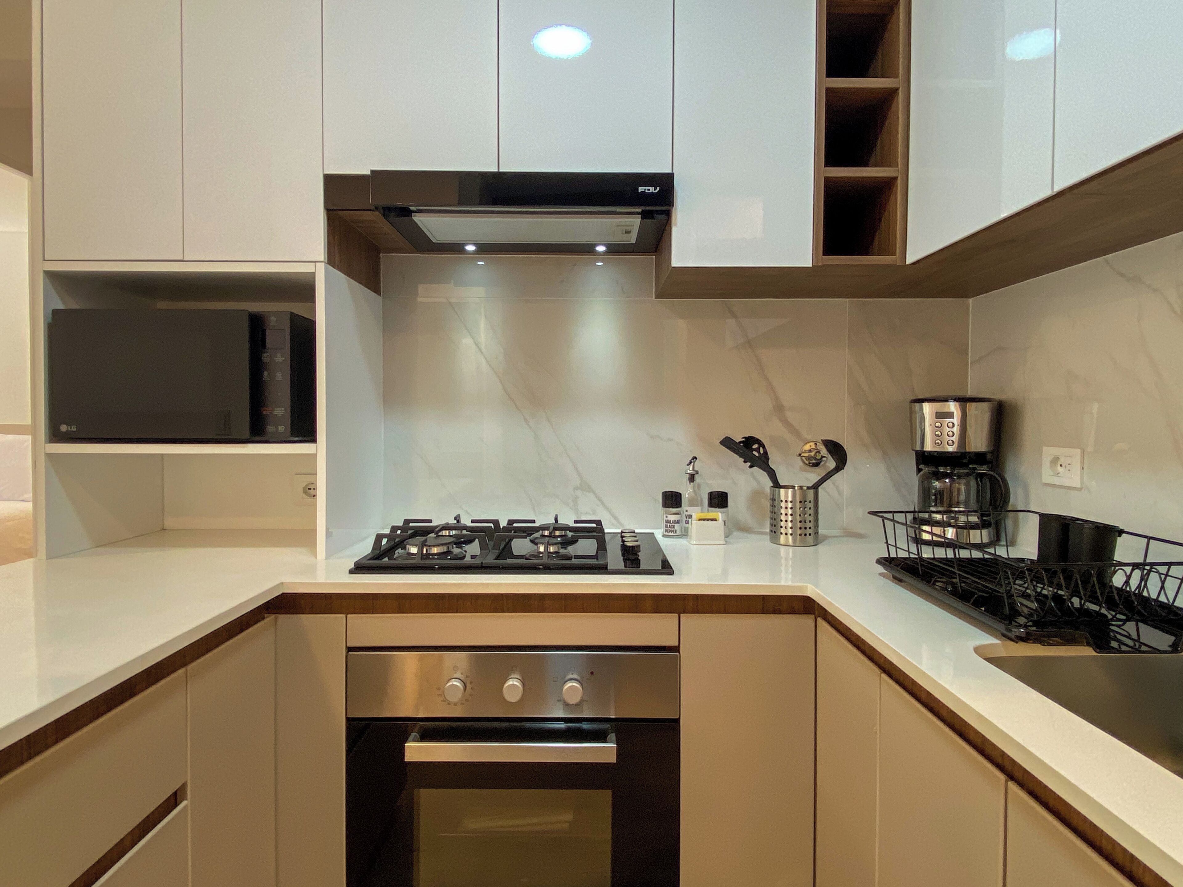 Una cocina moderna con estufa a gas, horno y cafetera.
