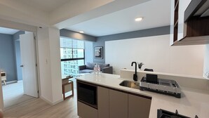 A modern kitchen with a built-in island, a sink, and a window overlooking a cityscape. - Amme by Wynwood House (Lima)