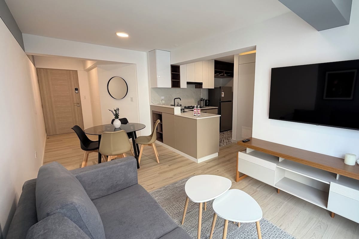 Un appartement moderne comprenant un salon, une cuisine et un coin repas.