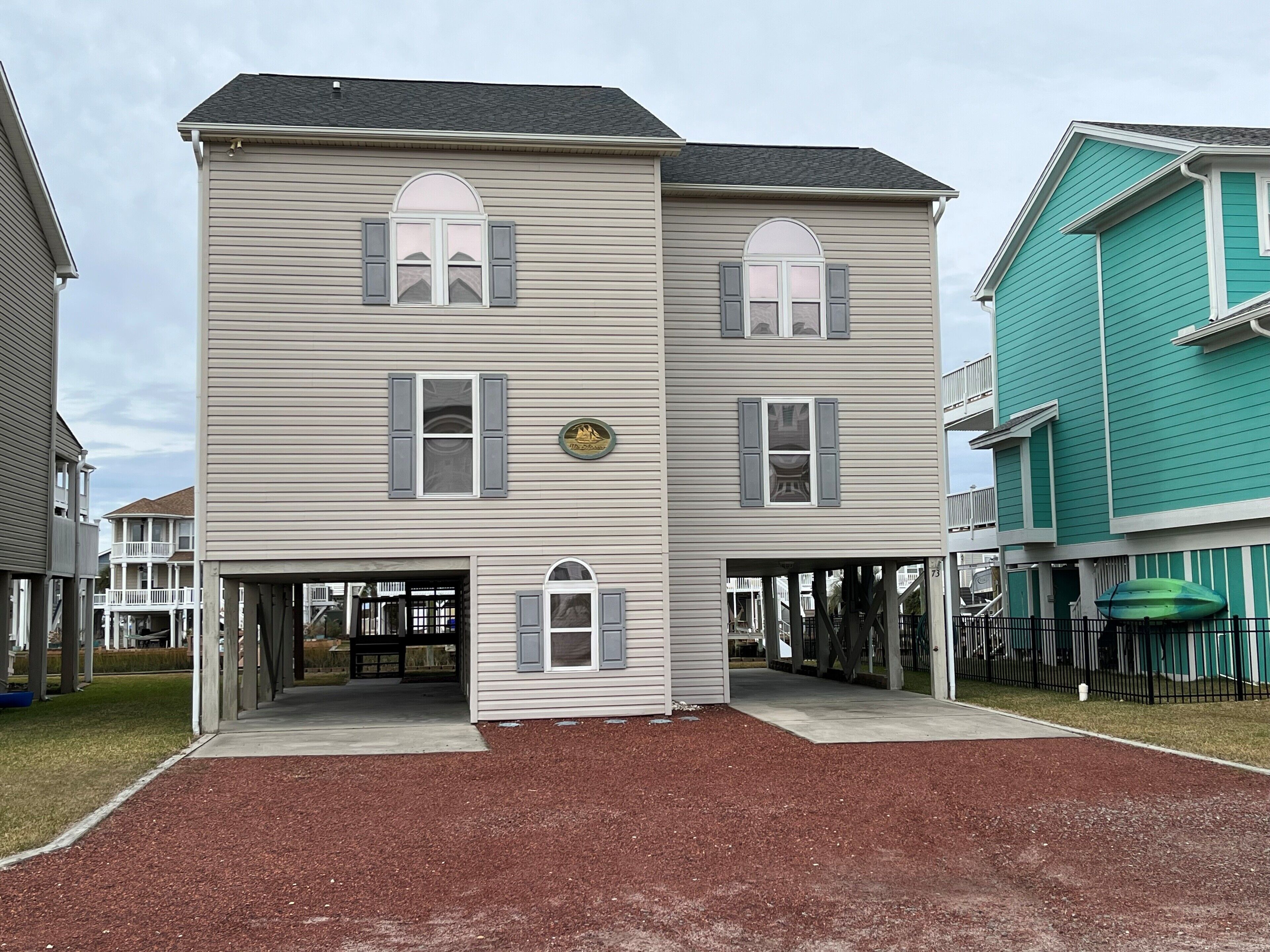 A two-story building with a flat roof, a front porch, and a small sign above the entrance.