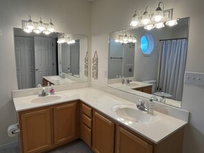 A bathroom with two sinks, large mirrors, and overhead lighting. - CANAL HOME - OPEN WEEKS! LINENS PROVIDED! (Ocean Isle Beach)