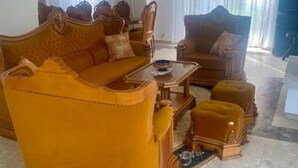 Una sala de estar con un sofá, sillones y una mesa de centro.