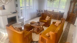 Una sala de estar con chimenea, un conjunto de sofás y un mueble de madera.