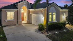 Una casa residencial con garaje, entrada para vehículos y césped bien cuidado.
