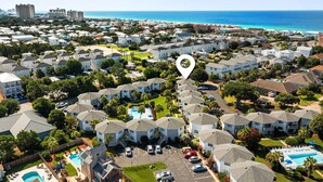 A residential area with multiple two-story houses, a swimming pool, and a view of the ocean. - Crystal Village II 26A (Miramar Beach)