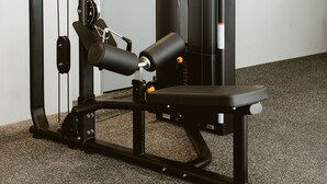 A gym with a squat rack, bench press, and weight plates. - Master Luxo Jardins Almare - By Almare (João Pessoa)