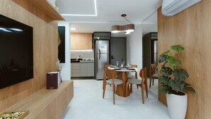 A modern kitchen with wooden cabinetry, a built-in TV, and a dining area with a round table and chairs. - Master Luxo Jardins Almare - By Almare (João Pessoa)