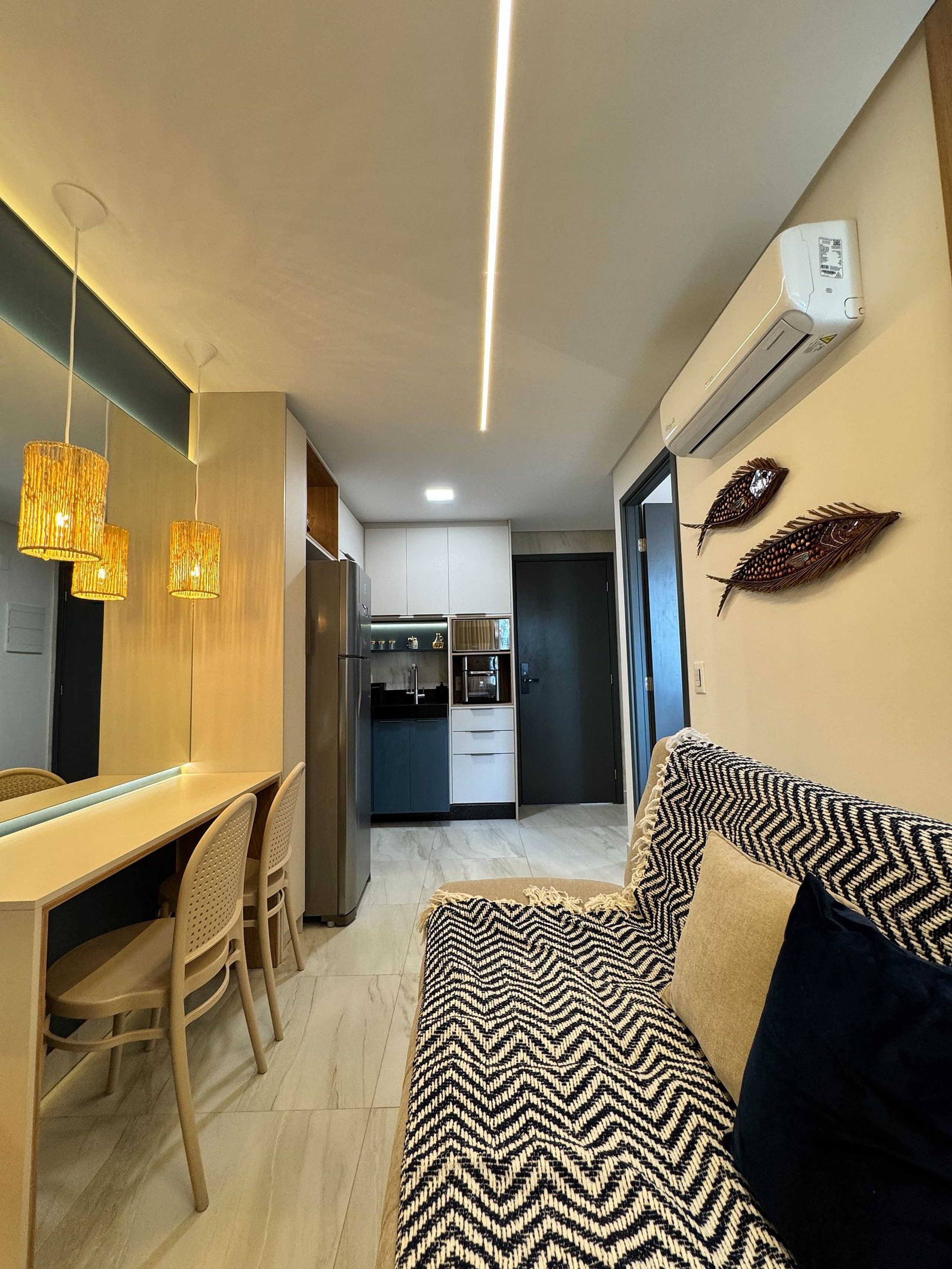 Una cocina moderna con comedor, sofá y decoración mural.