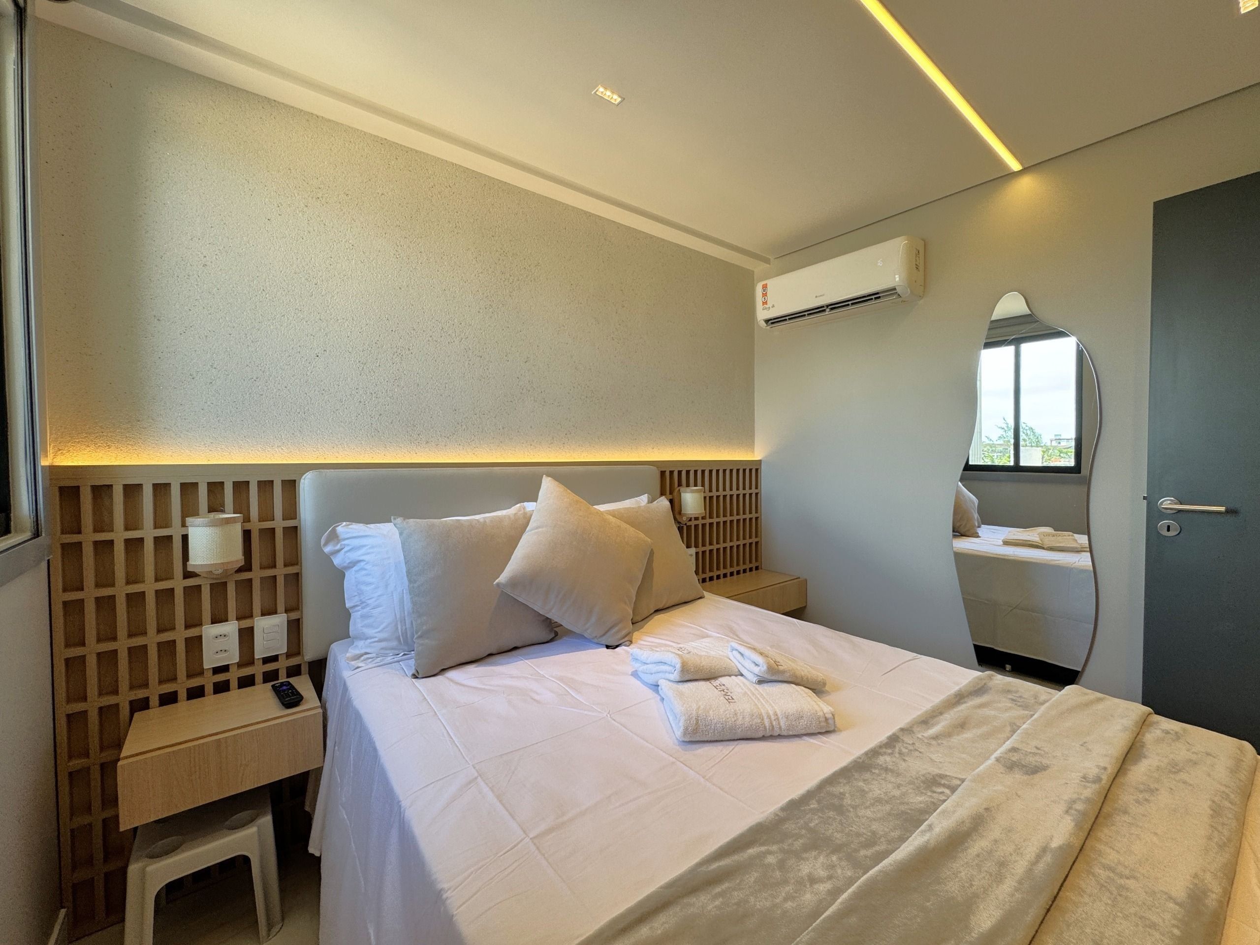 Une chambre d’hôtel équipée d’un lit, d’une table de chevet, d’une commode et d’un appareil de climatisation.