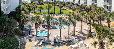 Un resort con zona de piscina, palmeras y vistas al océano.