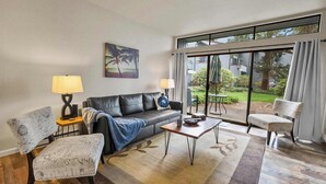 A living room with a sofa, two chairs, a coffee table, and a painting on the wall. - Ground Floor 2 bed Condo at Jacob's Landing (Blaine)