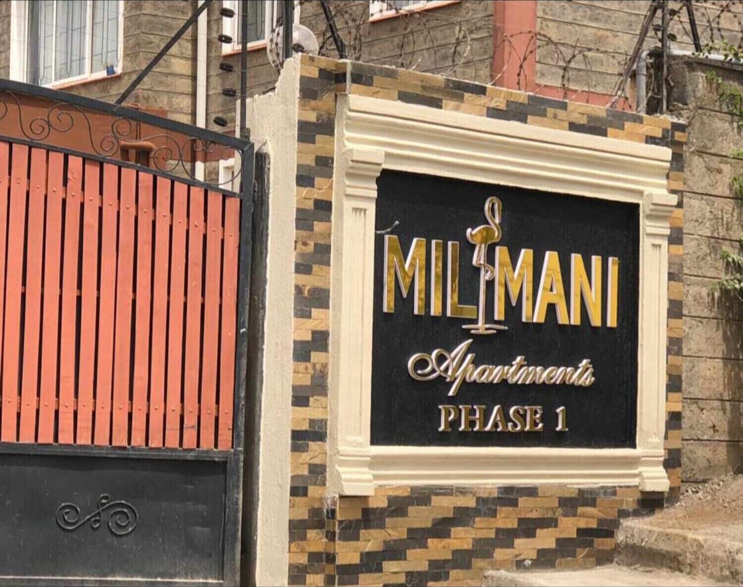 En lukket indgang med skilt for 'Milmani Apartments Første etape'.