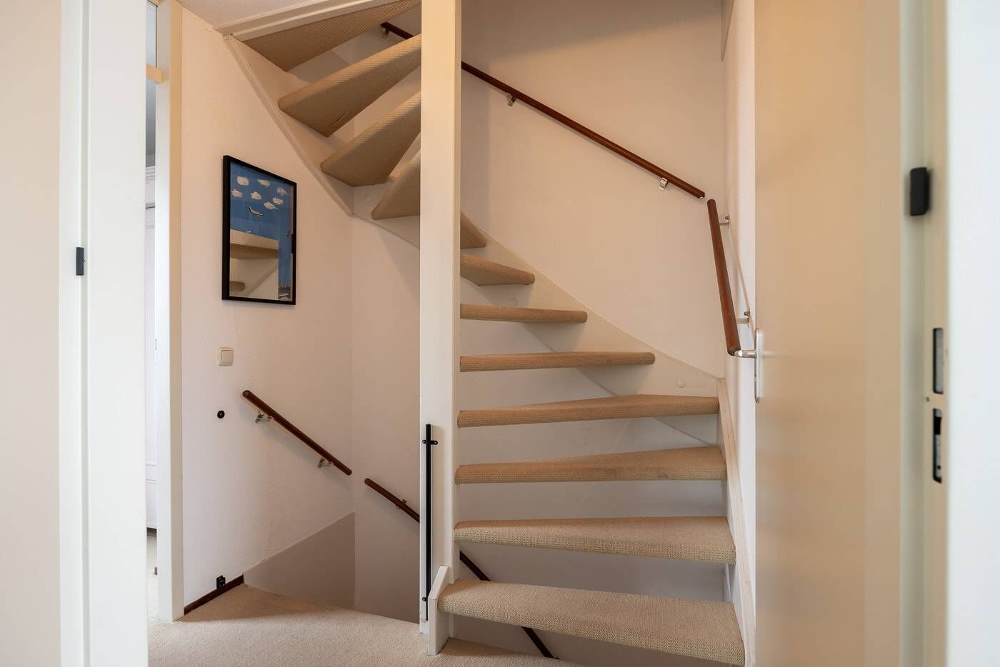 Eine Treppe mit Holzboden und Handlauf, die zu einer oberen Etage führt.
