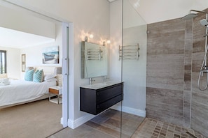A modern bedroom with a bed, bedside table, and a large window. - Ocean Whisper Sandown Bay | Nature and ocean waves at your doorstep (Mereenbosch)