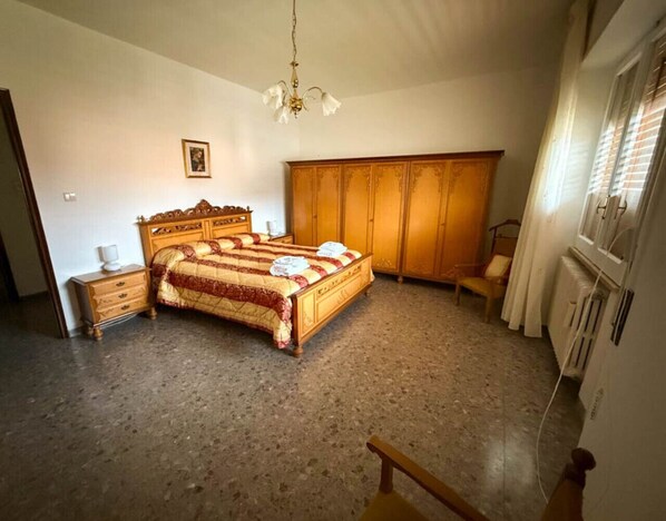 A bedroom with a bed, wooden wardrobe, a chair, and a radiator. - Casa Vacanze da Francesco (Lettopalena)
